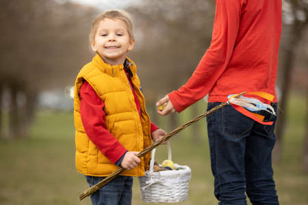 Cute preschool child, whipping his sister on Easter with twig, braided whip made from pussy willow,...