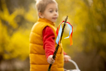Cute preschool child, boy, holding handmade braided whip made from pussy willow, traditional symbol...