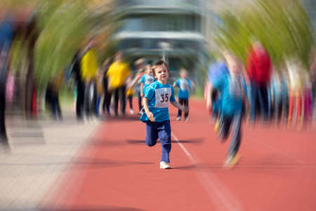 Young preschool children, running on track in a marathon competition, radial blurred motionの写真素材