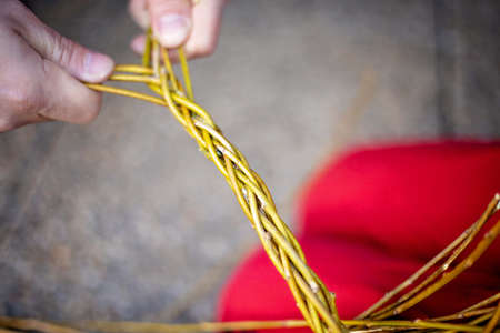 Man, teaching his child how to weave his easter whip from a rod for the holiday