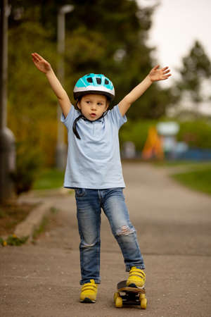 Little child, toddler boy, riding skateboard in the park for the first time, tryingの写真素材