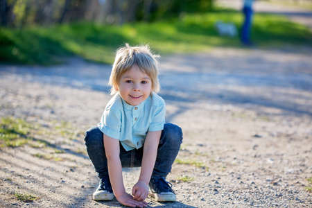 Beautiful child, boy kid, playing in the park on a sunny spring day