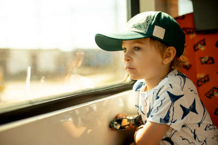 Cute little child, boy, traveling on a train, summertimeの写真素材