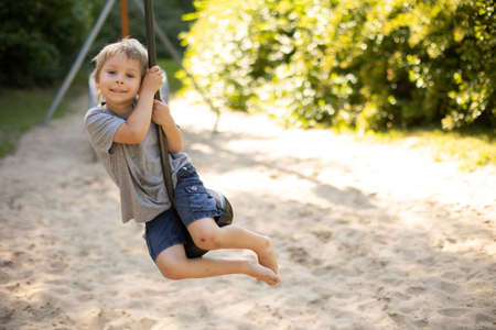 Cute child, playing on the playground, boy playing summertimeの写真素材