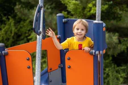 Cute child, playing on the playground, boy playing summertimeの写真素材