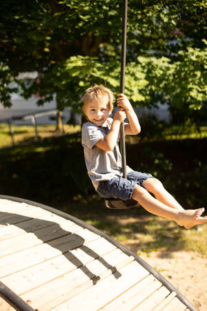 Cute child, playing on the playground, boy playing summertimeの写真素材