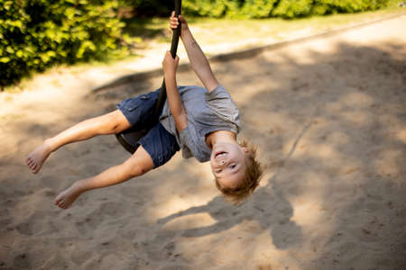 Cute child, playing on the playground, boy playing summertimeの写真素材