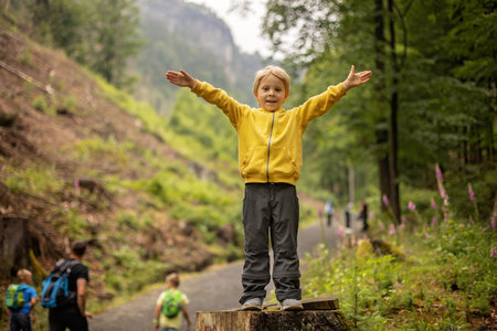 Child, boy, visiting Pravcicka brana in Hrensko, Czech Republic on a rainy summer day with his parentsの写真素材