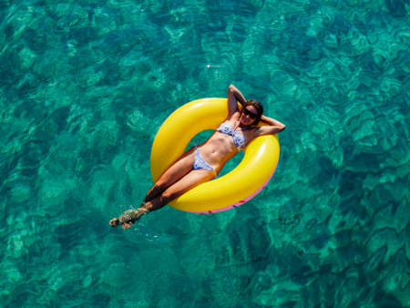 Picture with drone of people, floating on inflatable colorful rings in the seaの写真素材