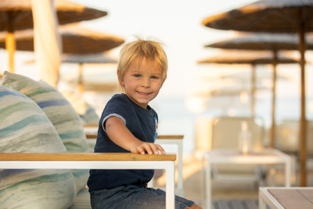 Happy child with family, ejoying the beach alley in Sarti, Greece on sunset, summertimeの写真素材
