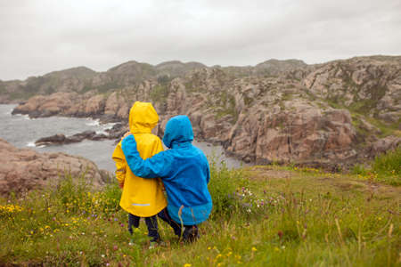 Family with children, visiting the Lindesnes Fyr Lighthouse in Norway on a rainy cold dayの写真素材