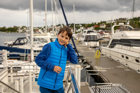 Child, visiting little town in south Norway, Arendal, on a rainy summer day, enjoying splendid viewsの写真素材