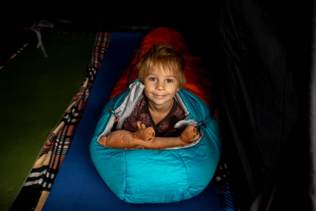 Children, sibilngs, sleeping in sleeping bags in a tent in Norway, wild camping