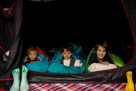 Children, sibilngs, sleeping in sleeping bags in a tent in Norway, wild campingの写真素材