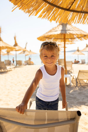 Child, cute boy, playing on the beach in the sand, enjoying summer, number signの写真素材