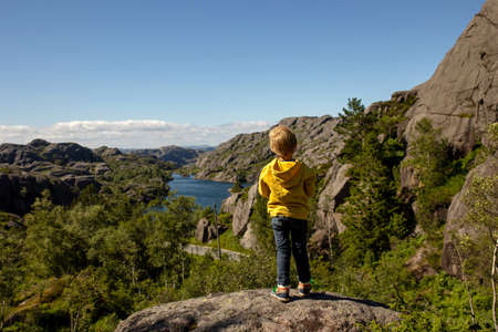 Happy people, enjoying amazing views in South Norway coastline, fjords, lakes, beautiful nature. Kids and adults traveling in Norway summertimeの写真素材