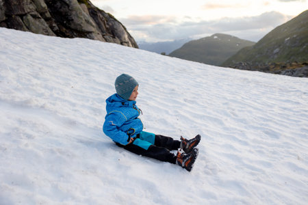 Child, boy, enjoying snow on mount Hoven, splendid view over Nordfjord from the Loen skyliftの写真素材