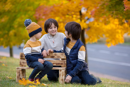 Happy family, mother with children, having their autumn pictures taken in the park, children playingの写真素材