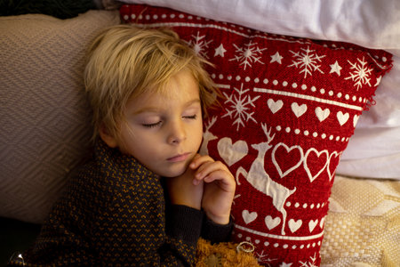Cute child, boy, sleeping in decorated room for Christmas, cozy placeの写真素材