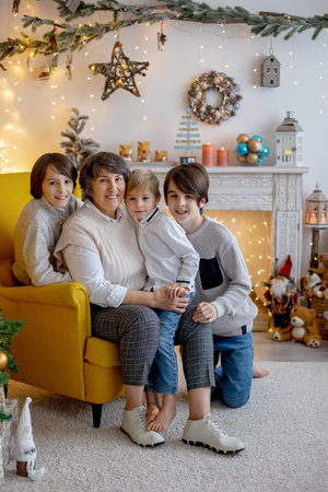 Christmas family picture in cozy home with lights and decoration, grandmother, mother and children