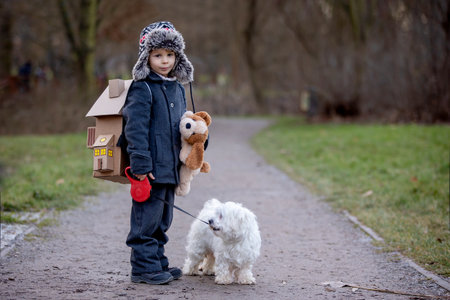 Little child, blond boy with pet dog, carying home on his back, kid, having paper house, emotional...