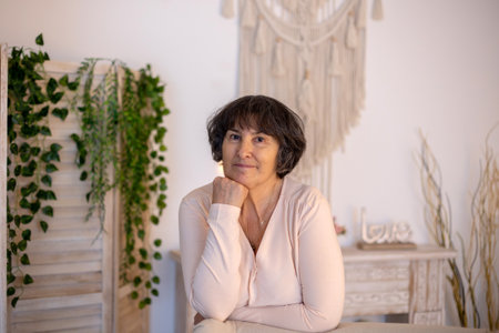 Elderly woman, posing at home, sitting on sofa or bedの写真素材