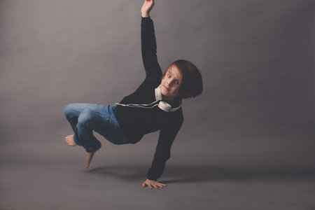 Sweet child, boy in black sweater, listening music, isolated backgroundの写真素材