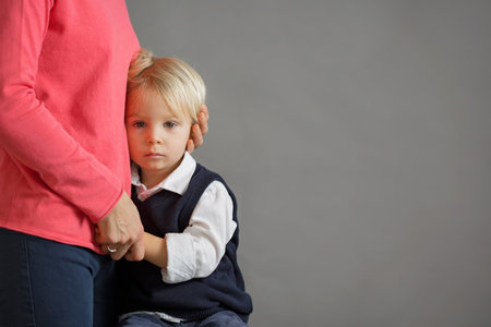 Sad little child, boy, hugging his mother at home, isolated image, copy space. Family concept