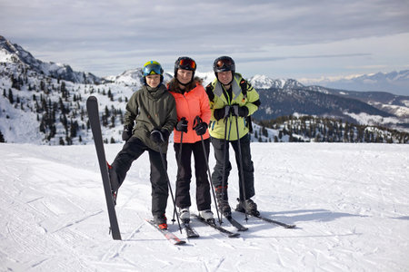 Happy family, enjoying ski holiday with children, sunny beautiful weather outdoorsの写真素材