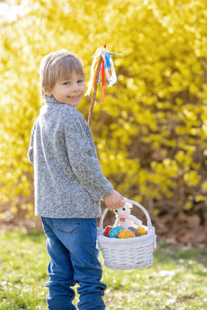 Cute preschool child, boy, holding handmade braided whip made from pussy willow, traditional symbol...
