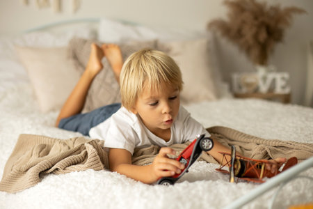 Cute preschool boy, playing with airplane, balloons and birthday decoration in the backgroundの写真素材
