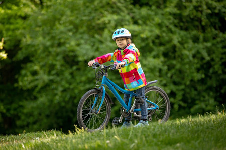 Happy kid boy, having fun in park with a bicycle on beautiful day. Active childの写真素材