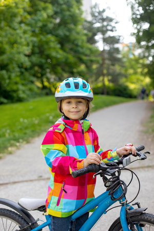 Happy kid boy, having fun in park with a bicycle on beautiful day. Active childの写真素材