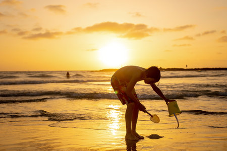 Happy teenager boys, running and playing on the beach on sunset, splashing water and jumping on the sand. Tel Aviv, Israelの写真素材