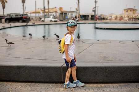 Cute child, boy, playing with water in fountain in Tel Aviv, lights and colorsの写真素材