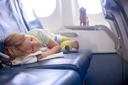 Cute preschool child, boy, flying on a long distant flight, sleeping in the airplaneの写真素材