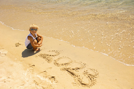 Child, cute boy, playing on the beach in the sand, enjoying summer, numberの写真素材
