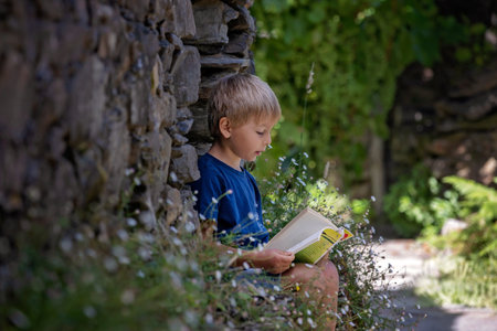 Beautiful medieval village Talasnal in Lousa, Portugal on a beautiful day. Child playing on the street of the village with his pet dog, reading bookの写真素材