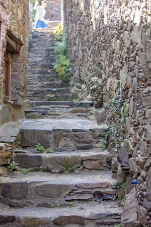 Beautiful medieval village Talasnal in Lousa, Portugal on a beautiful day. Child playing on the street of the village with his pet dog, reading bookの写真素材