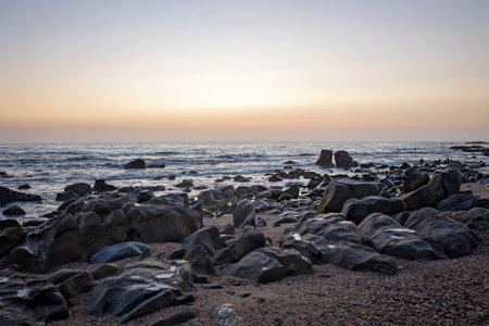 Happy children, enjoying sunset over the ocean with their family, rocky beach in Portugal