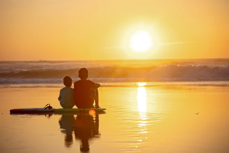 Happy children, boys, playing on the beach on sunset, kid cover in sand, smiling, laughing, enjoying...
