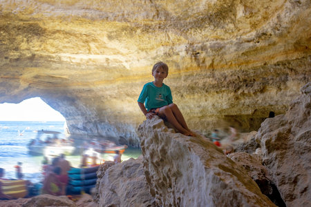 Children, enjoying Benagil, Portugal. Benagil Cave inside Algar de Benagil, famous sea cave in Algarve coast, Lagoa. Happy family on a canoe tripの写真素材