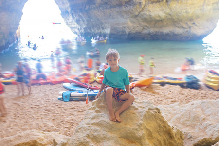 Children, enjoying Benagil, Portugal. Benagil Cave inside Algar de Benagil, famous sea cave in Algarve coast, Lagoa. Happy family on a canoe tripの写真素材