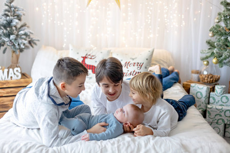 Happy family, newborn baby and older brothers, mom at home on Christmasの写真素材