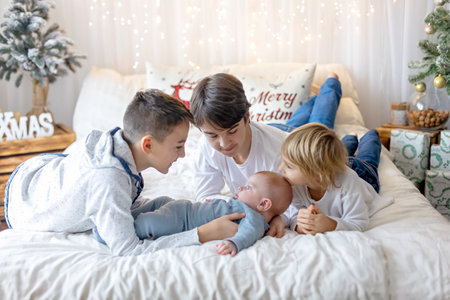 Happy family, newborn baby and older brothers, mom at home on Christmasの写真素材