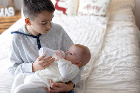 Happy family, newborn baby and older brothers, mom at home on Christmas