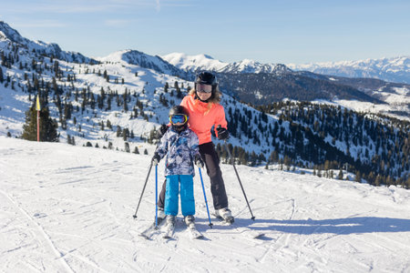 Children and adults, happy family in winter clothing at ski vacation, skiing, wintertimeの写真素材