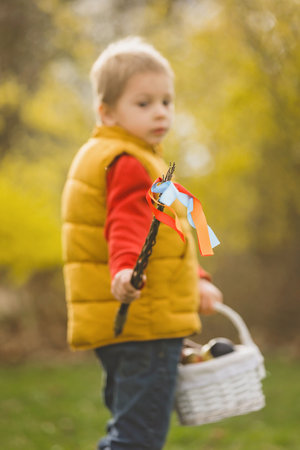 Cute preschool child, boy, holding handmade braided whip made from pussy willow, traditional symbol...