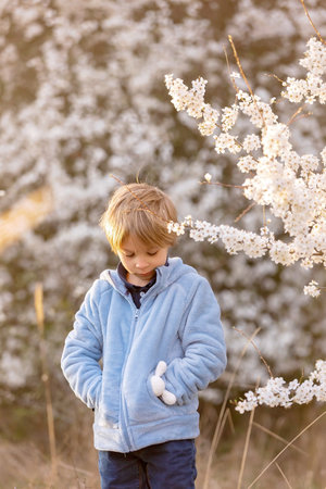 Beautiful blond child, boy, holding twig, braided whip made from pussy willow, traditional symbol of...