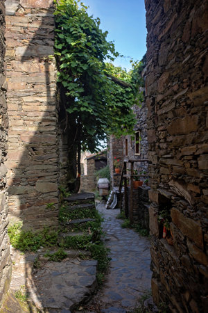 Beautiful medieval village Talasnal in Lousa, Portugal on a beautiful day. Child playing on the street of the village with his pet dog, reading bookの写真素材